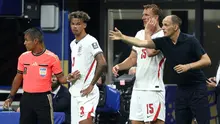 Pelatih Timnas Inggris, Thomas Tuchel, memberikan instruksi kepada Nico O'Reilly (kiri) dan Dan Burn sebelum keduanya masuk sebagai pemain pengganti pada laga semifinal Piala Dunia 2026 melawan Argentina di Atlanta Stadium, Atlanta, Kamis (16/7/2026)  dini hari WIB. (Richard Pelham/Getty Images/AFP)