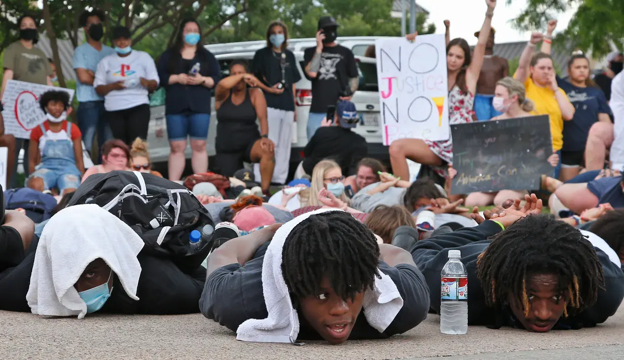 Ratusan demonstran berbaring telungkup menggambarkan George Floyd saat penangakapannya selama aksi di Norman Police Department, Oklahoma, Rabu (3/6/2020). Aksi tersebut menyimbolkan momen terakhir Floyd saat lehernya ditindih lutut oleh polisi Minneapolis pada 25 Mei lalu. (AP/Sue Ogrocki)