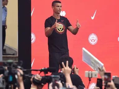 Pemain timnas Portugal, Cristiano Ronaldo mengacungkan jempolnya ketika menyapa penggemar saat rangkaian “CR7 Tour” yang disponsori Nike di Beijing, Kamis (19/7). Pemain berjuluk CR7 itu terbang ke China dengan menaiki jet pribadi. (WANG ZHAO/AFP)