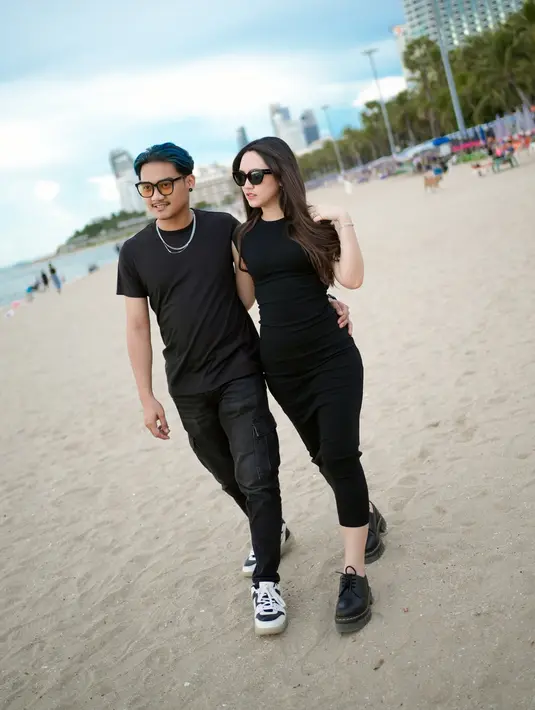 Menikmati momen liburan santai bersama ke pantai, memang menjadi salah satu pilihan keduanya dalam menikmati waktu bersama. Pasangan baru yang belum lama menikah ini memang kerap menuai perhatian dengan tingkah romantis keduanya yang menuai banyak pujian. (Liputan6.com/IG/@happy_asmara77)