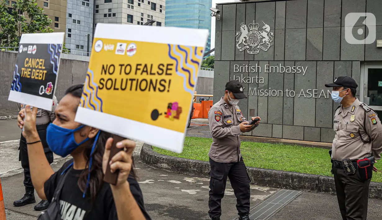 Massa yang tergabung dalam Walhi DKI Jakarta dan KRuHa menggelar aksi protes simbolik di depan Kedutaan Besar Inggris, Jakarta, Jumat (11/6/2021). Aksi yang bertepatan dengan pertemuan puncak G7 tersebut menolak utang baru untuk penanggulangan COVID-19. (Liputan6.com/Faizal Fanani)