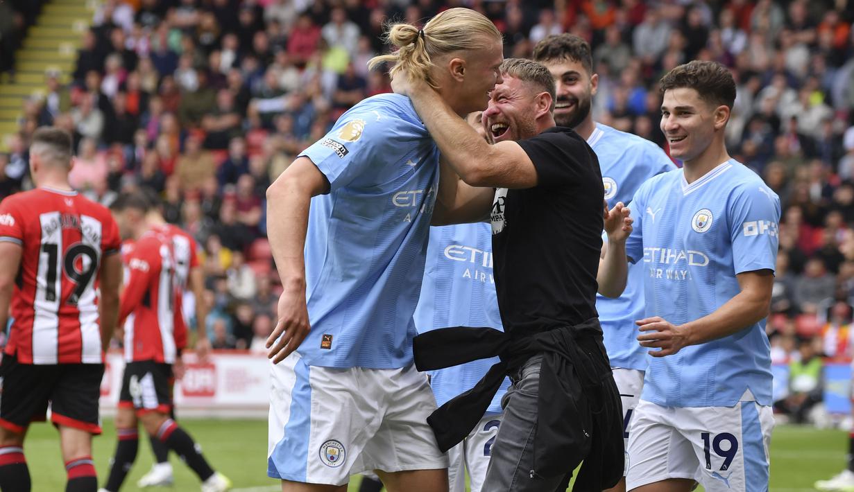 Setelah mencetak gol, Haaland terlihat berjalan pelan di pinggir lapangan. Pada saat yang bersamaan ada fans City yang melompat dan berusaha memeluk Haaland. (AP Photo/Rui Vieira)