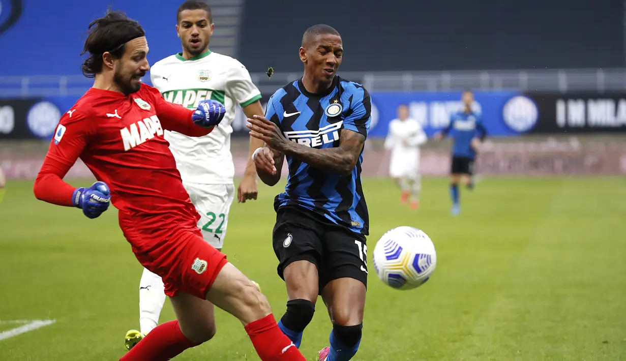 Kiper Sassuolo, Andrea Consigli dan bek  Inter Milan, Ashley Young bersaing memperbutkan bola pada laga tunda Liga Italia di Stadio Giuseppe Meazza, Kamis (8/4/2021) dini hari WIB. Bermain di kandang, Inter Milan mengalahkan Sassuolo dengan skor 2-1. (AP Photo/Antonio Calanni)