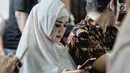 Penyanyi sekaligus istri musisi Ahmad Dhani, Mulan Jameela bermain handphone saat menghadiri sidang lanjutan kasus ujaran kebencian yang melibatkan sang suami di PN Jakarta Selatan, Senin (17/9). (Liputan6.com/Faizal Fanani)