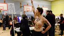 Seorang wanita bertelanjang dada meneriakkan kalimat protes saat melakukan demonstrasi di TPS Pilpres AS 59, di mana Donald Trump memberikan suaranya di New York, Selasa (8/11). Dalam aksi ini mereka meneriakkan slogan anti-Trump. (REUTERS/Darren Ornitz)