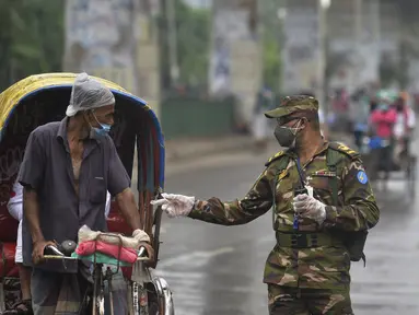 Tentara Bangladesh memeriksa seorang pria yang bepergian dengan becak di sebuah pos pemeriksaan sepanjang jalan Dhaka, Bangladesh, Kamis (1/7/2021). Tentara dan polisi diperintahkan untuk mencegah orang-orang keluar rumah, kecuali untuk keadaan darurat atau membeli kebutuhan pokok. (AFP/Munir Uz zam