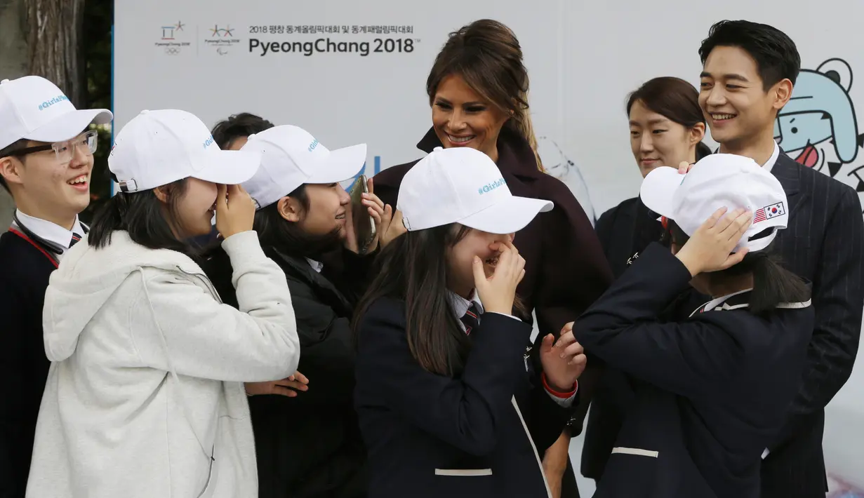 Para siswa menyambut Ibu Negara AS, Melania Trump ditemani personel boyband SHINee, Choi Min-ho pada acara 'Girls Play 2!', kampanye Olimpiade Musim Dingin PyeongChang 2018, di Kedutaan Besar AS di Seoul, Selasa (7/11). (AP Photo/Ahn Young-joon. Pool)