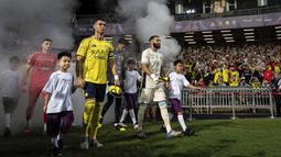 Cristiano Ronaldo memimpin rombongan pemain Al-Nassr saat memasuki lapangan pertandingan dalam laga semfinal Saudi Super Cup 2025 melawan Al-Ittihad di Hong Kong Stadium, Hong Kong, Selasa (19/08/2025) waktu setempat. (AP Photo/Chan Long Hei)