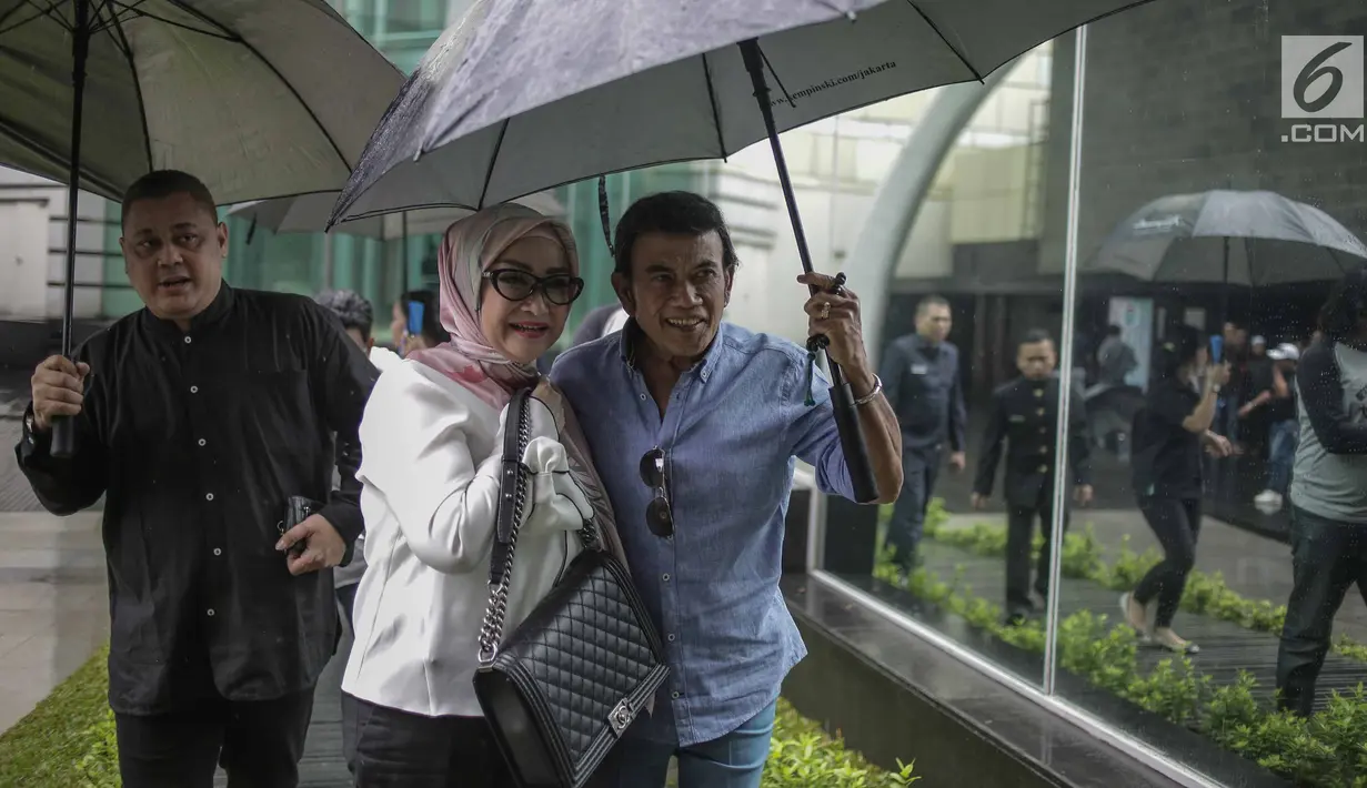 Rhoma Irama memayungi istrinya Ricca Rachim saat hadir dalam konferensi pers indosiar Ramadhan Penuh Berkah di Jakarta, Kamis (26/4). Rhoma Irama terlihat romantis saat memayungi istrinya Ricca Rachim. (Liputan6.com/Faizal Fanani)
