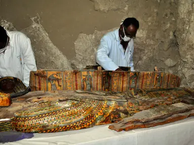 Arkeolog Mesir meneliti mumi yang ditemukan di sebuah pemakaman berumur 3.500 tahun, sebelah selatan kota Luxor, Selasa (18/4). Para arkeolog menemukan delapan mumi, peti mati kayu warna-warni serta lebih dari 1.000 patung pemakaman. (STRINGER/AFP)