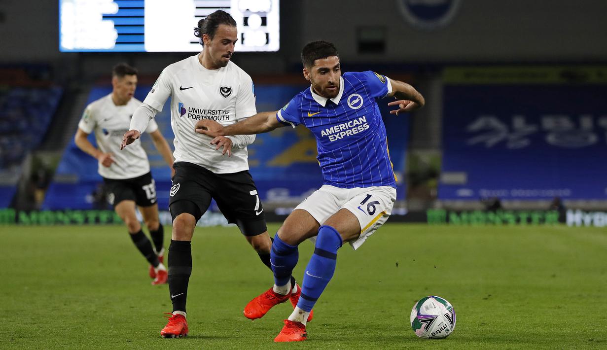 Gelandang Brighton, Alireza Jahanbakhsh, berebut bola dengan gelandang Portsmouth, Ryan Williams, pada laga Piala Inggris di Falmer Stadium, Jumat (18/9/2020) dini hari WIB. Brighton menang 4-0 atas Portsmouth. (AFP/Paul Childs/pool)
