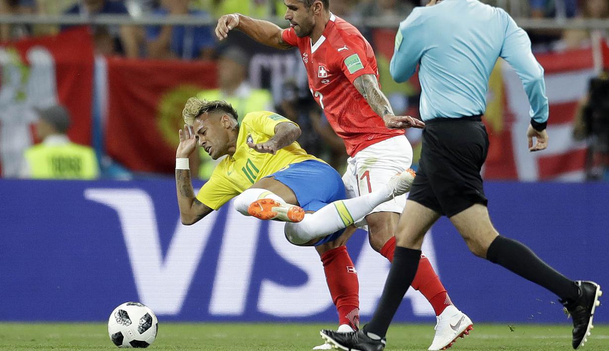 Striker Brasil, Neymar, terjatuh saat berebut bola dengan gelandang Swiss, Valon Behrami, pada laga Piala Dunia di Stadion Rostov, Rusia, Senin (17/6/2018). Dilanggar sebanyak 10 kali membuat Neymar masuk rekor di Piala Dunia. (AP/Felipe Dana)