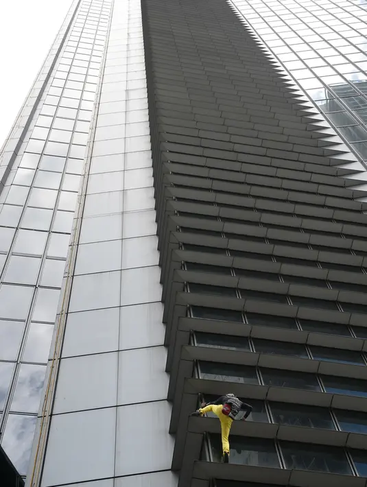 Alain Robert berusaha memanjat Menara Internasional GT berlantai 47 di Makati City, Manila, Filipina (29/1). Pria berusia 56 tahun itu memanjat Menara GT 47 lantai tanpa peralatan keselamatan dan menjadi tontonan warga. (AFP Photo/Ted Aljibe)