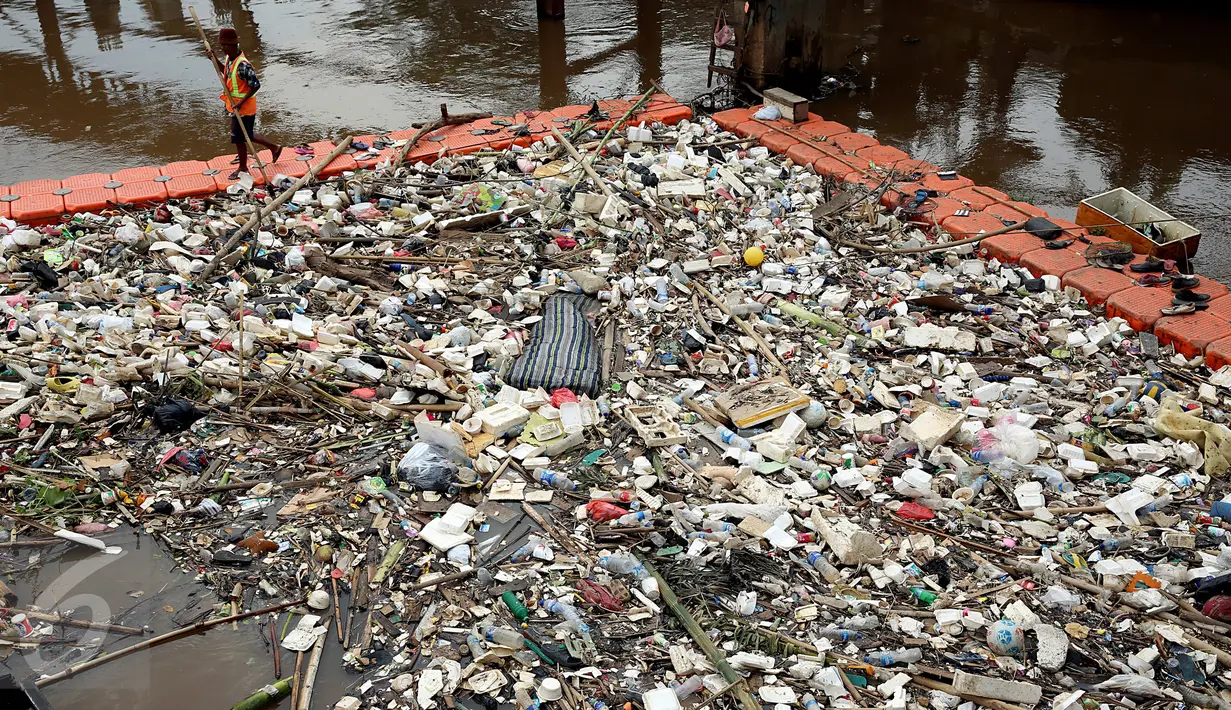 Pekerja kebersihan membersihkan sampah di Sungai Kanal Banjir Barat, Jakarta, Senin (14/11). Hujan yang terjadi di hulu Banjir Kanal Barat mengakibatkan meningkatnya debit air yang disertai sampah. (Liputan6.com/Johan Tallo)