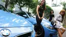Tiga model berpose diantara mobil BMW F Series dalam acara 4th Komunitas BMW F Series di Jakarta, Sabtu (24/3). Komunitas F Series merupakan kumpulan para penggemar kendaran BMW dengan kode sasis 'F'. (Liputan6.com/Pool/Bio)
