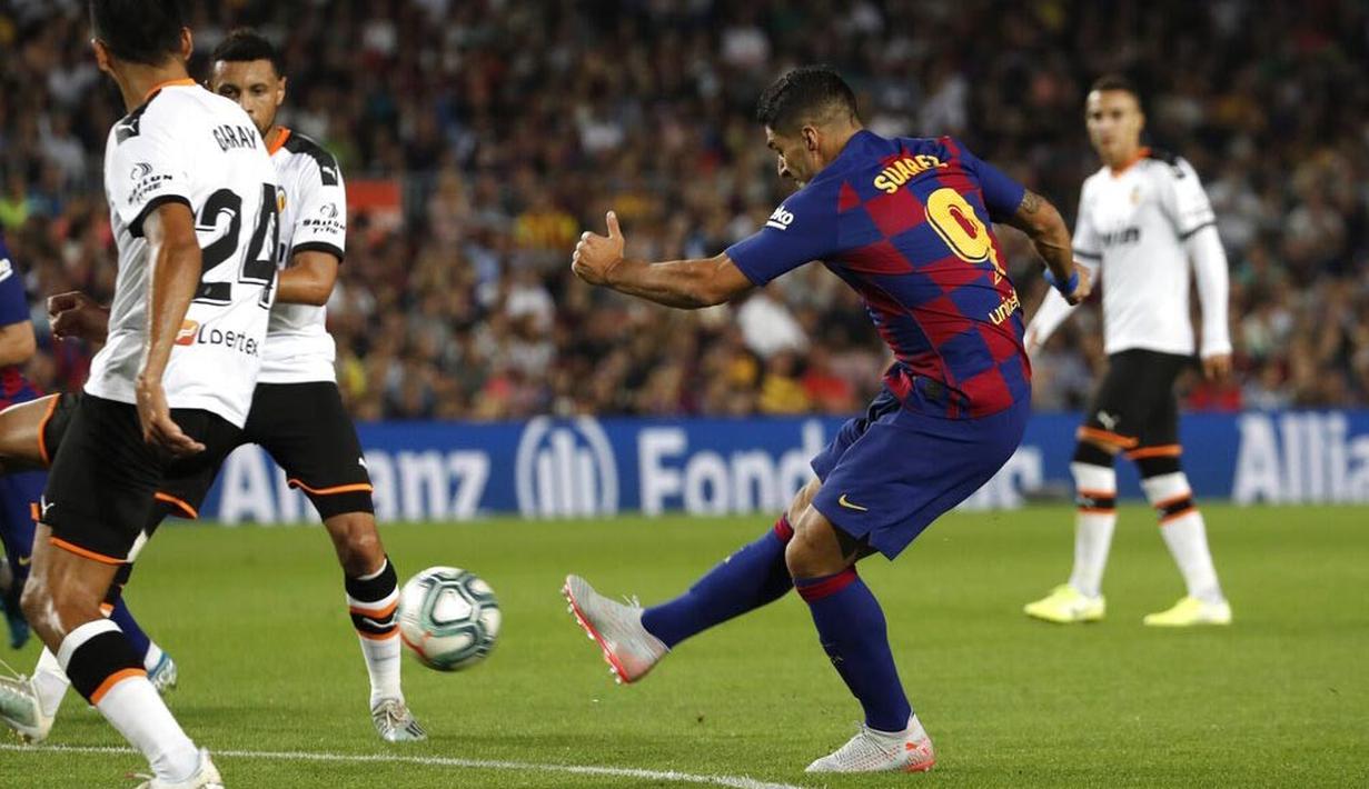 Striker Barcelona, Luis Suarez, melepaskan tendangan ke gawang Valencia pada laga La Liga di Stadion Camp Nou, Sabtu (14/9). Barcelona menang 5-2 atas Valencia. (AP/Joan Monfort)