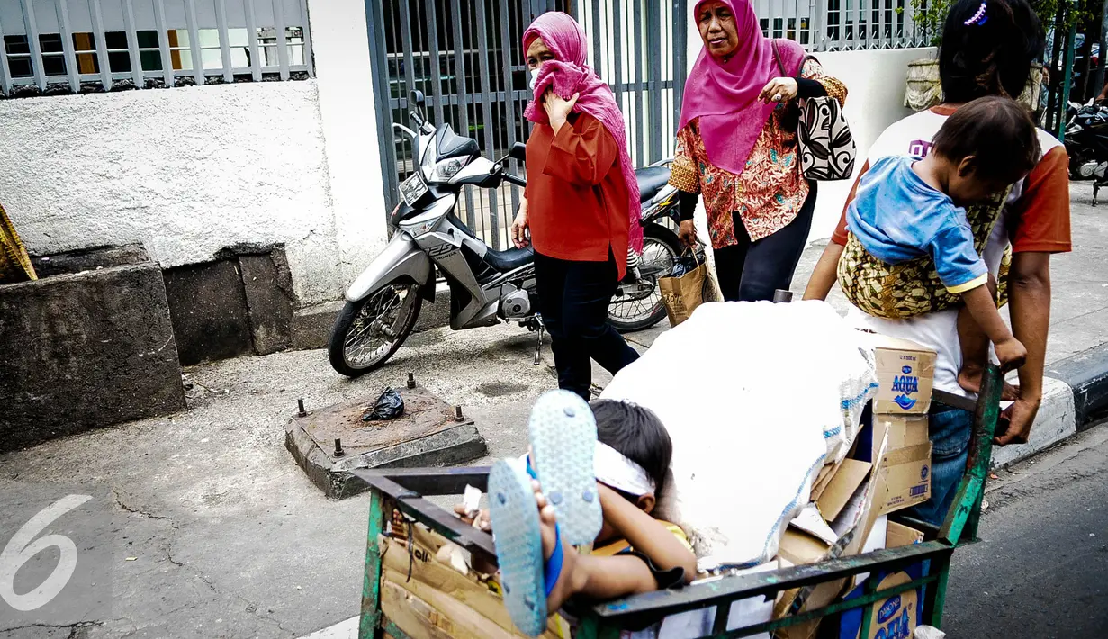 Seorang ibu membawa anaknya mencari barang bekas dengan gerobak melintasi kawasan Wahid Hasyim, Jakarta, Kamis (6/10). Penduduk miskin di DKI Jakarta meningkat sebesar 15.630 orang atau meningkat 0,14% dari tahun sebelumnya. (Liputan6.com/Faizal Fanani)