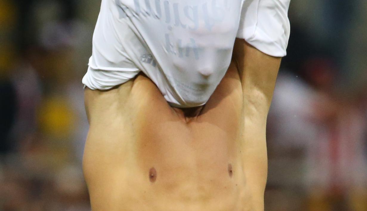  Bintang Real Madrid, Cristiano Ronaldo melepas baju usai mencetak gol penentuan kemenangan timnya pada Final Liga Champions di San Siro Stadium, Milan, (29/5/2016) WIB.  (Reuters/Stefano Rellandini)