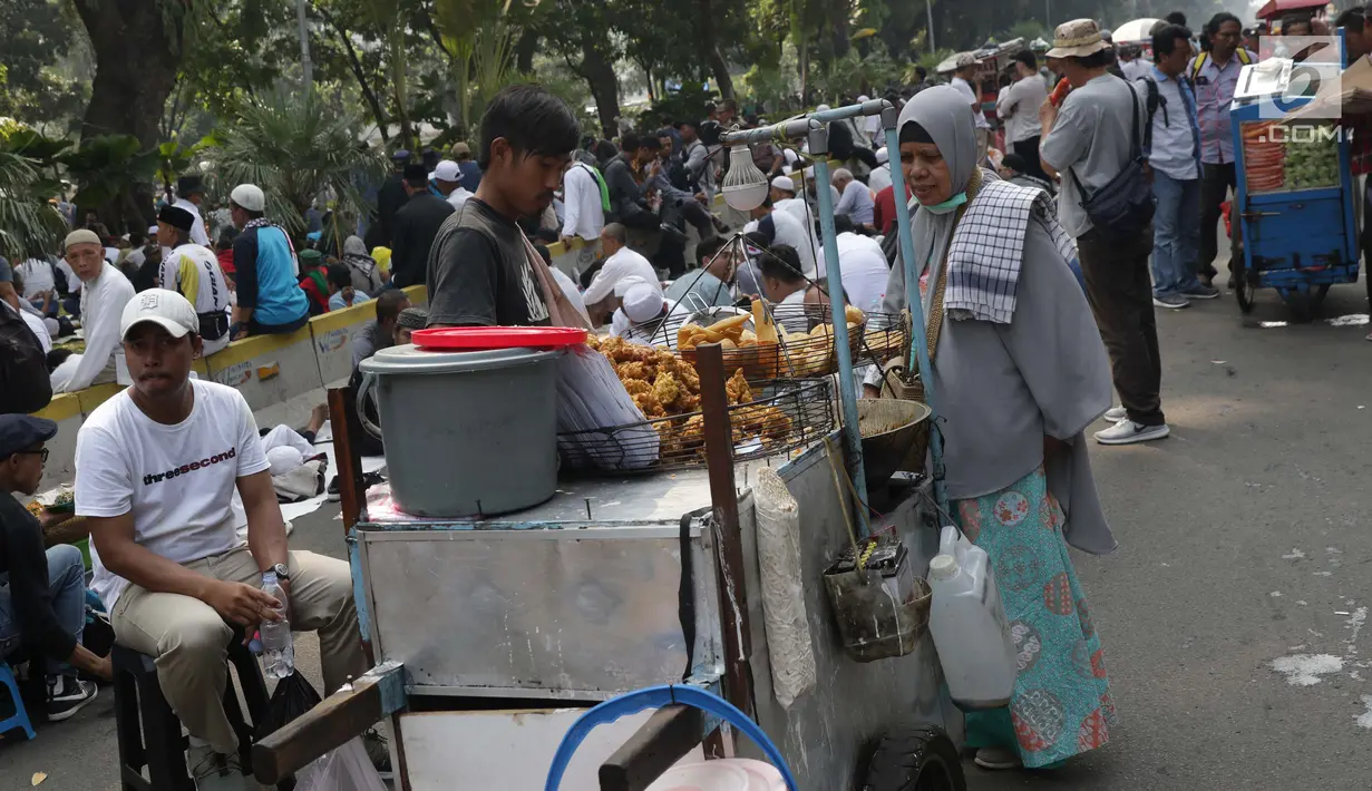 Pedagang asongan melayani pembeli yang mayoritas massa yang melakukan aksi di sekitaran Jalan Medan Merdeka Barat, Jakarta, Kamis (27/6/2019). Massa yang melakukan aksi terkait sidang putusan perselisihan hasil Pilpres 2019 memberi keuntungan bagi para pedagang. (Liputan6.com/Helmi Fithriansyah)