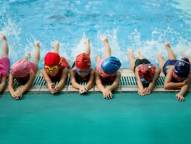 Sejumlah anak melakukan pemanasan sebelum latihan berenang di sekolah Hangzhou Chen Jinglun Sport sekolah Natatorium, Hangzhou, provinsi Zhejiang, China, (10/8). Sekolah ini pernah melatih perenang Olimpiade Sun Yang dan Fu Yuanhui. (REUTERS/Aly Song)