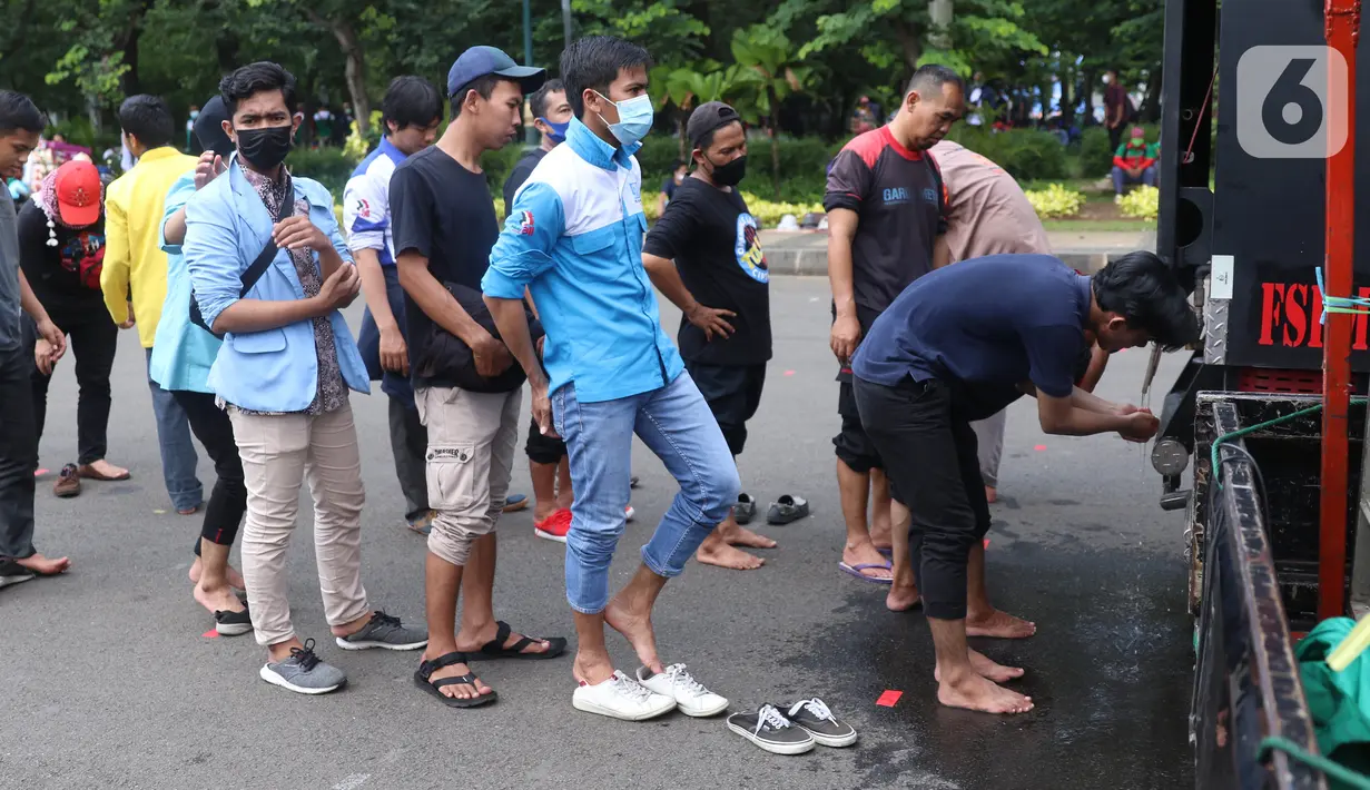 Sejumlah buruh mengambil air wudhu untuk menunaikan salat zuhur di sela aksi Hari Buruh Internasional atau May Day di Jakarta, Sabtu (1/5/2021). Sejumlah massa yang tergabung dalam serikat pekerja menggelar unjuk rasa di Hari Buruh ini. (Liputan6.com/Angga Yuniar)
