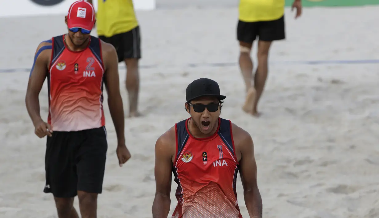 Pevoli pantai Indonesia, Ade Chandra dan Muhammad Ashfiya, merayakan kemenangan atas Thailand pada laga final voli pantai beregu putra SEA Games di Subic Court Tennis, Filipina, Jumat (6/12). Indonesia berhasil meraih emas. (Bola.com/M Iqbal Ichsan)
