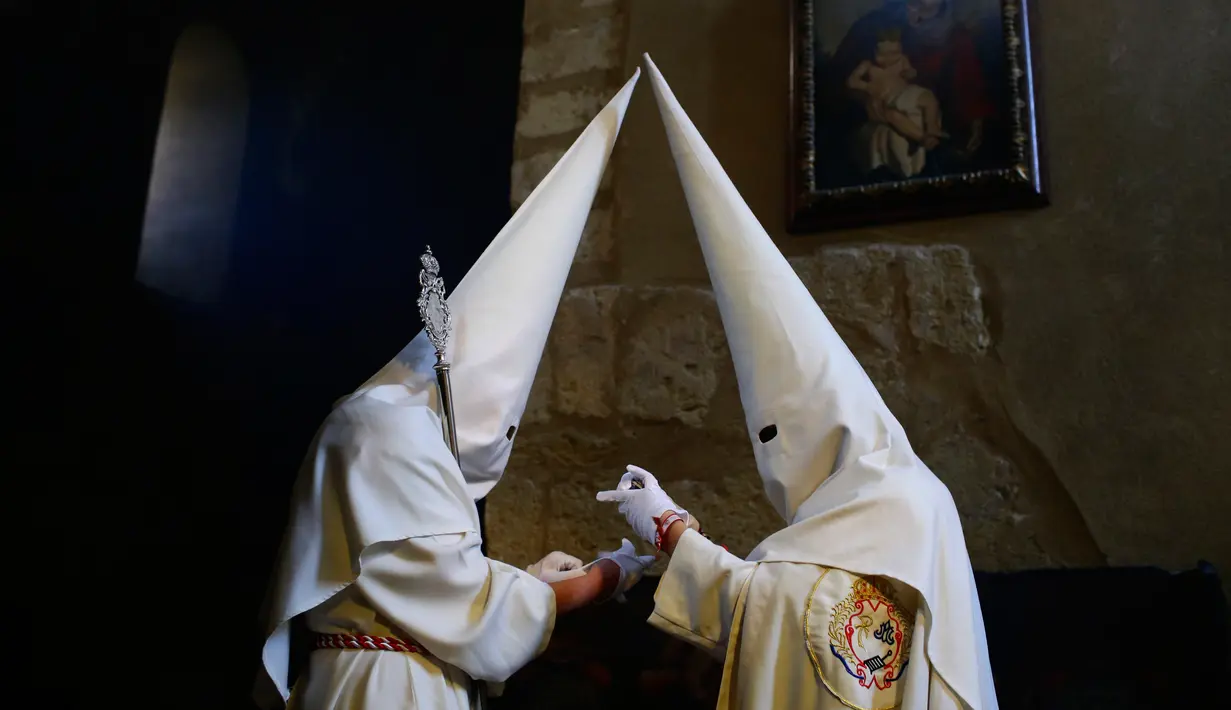 Anggota persaudaraan "La Borriquita" bersiap mengikuti pengakuan dosa dalam acara prosesi Pekan Suci di Cordoba, Spanyol (9/4). Mereka bertobat di depan umum dengan menutupi wajah untuk agar tidak dapat diidentifikasi. (AP Photo / Manu Fernandez)