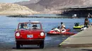 James Spear mengendarai mobil Amphicar 1964 usai berlayar berlayar pada festival Las Vegas Amphicar Swim di Danau Mead, Nevada, Jumat (9/10). (REUTERS/Steve Marcus)