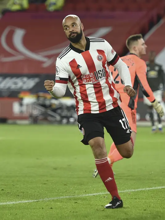 Pemain Sheffield United, David McGoldrick berselebrasi usai mencetak gol ke gawang Manchester United pada Liga Inggris di stadion Bramall Lane, Inggris, Jumat (18/12/2020). Tambahan tiga angka membawa MU ke peringkat keenam dengan 23 poin. (AP Photo/Peter Powell)