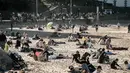 Penduduk dan turis duduk di pantai berpasir selama cuaca musim dingin yang hangat di Biarritz di Perancis barat (17/2). Kawasan pantai Biarritz yang berbatasan dengan Spanyol ini termasuk salah satu wilayah termahal di Prancis. (AFP Photo/Iroz Gaizka)