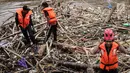 Petugas kebersihan saat mengenakan topeng Spiderman membersihkan sampah yang menumpuk di Pintu Air Manggarai, Jakarta, Senin (12/11). Sampah kiriman berasal dari wilayah Bogor dan Depok. (Liputan6.com/Fery Pradolo)