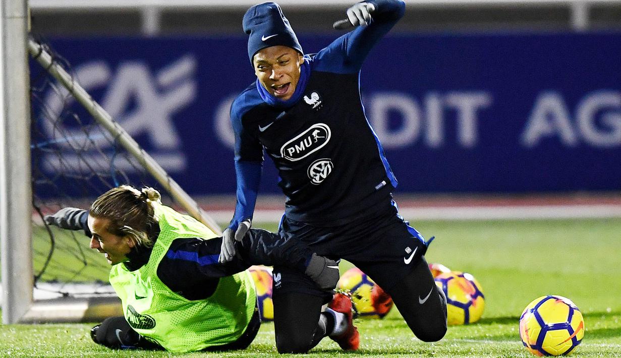 Striker Prancis, Kylian Mbappe dan Antoine Griezmann, terjatuh saat mengikuti sesi latihan jelang laga persahabatan di Paris, Selasa (7/11/2017). Prancis akan berhadapan dengan Jerman dan Wales. (AFP/Franck Fife)