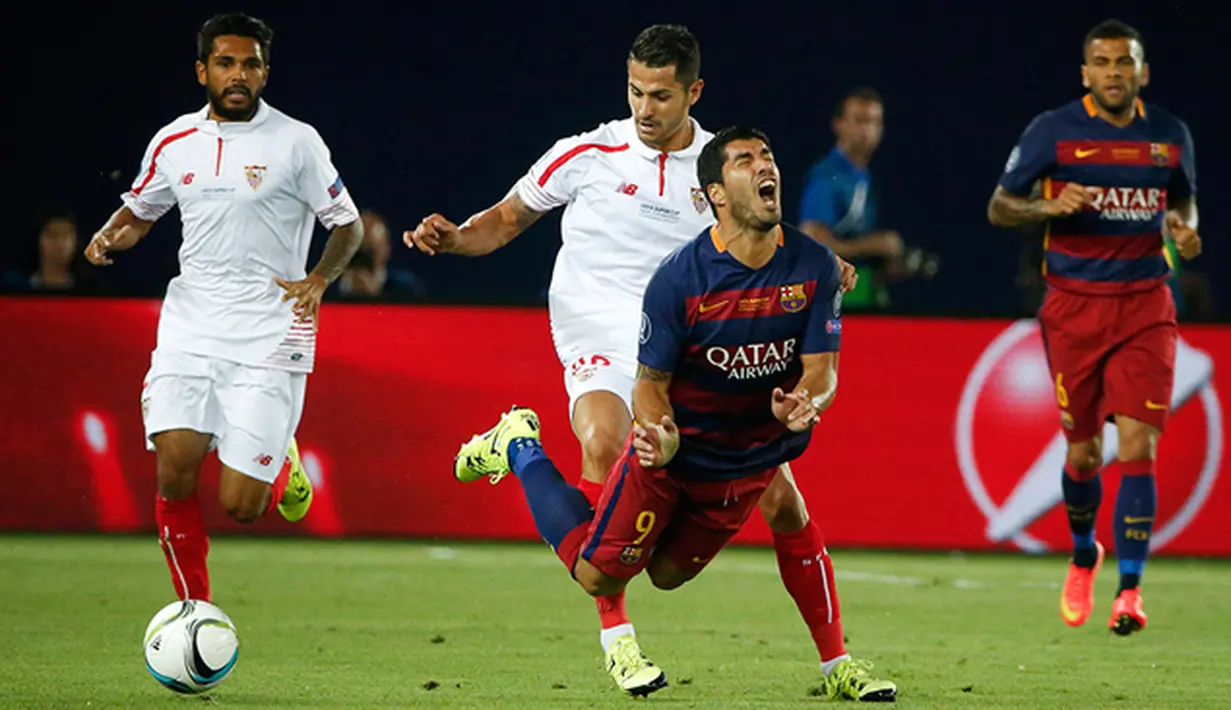 Pemain Barcelona, Luis Suarez terjatuh akibat didorong pemain Sevilla, Vitolo pada laga UEFA Super Cup di Tbilisi, Georgia, Selasa (11/8/2015). Bercelona menang 5-4 atas Sevilla. (Reuters/Grigory Dukor)