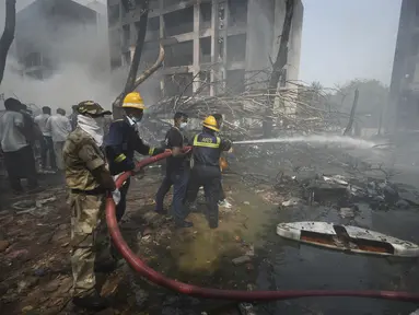 Petugas pemadam kebakaran bekerja di lokasi jatuhnya pesawat di kota Ahmedabad, negara bagian Gujarat, India Barat Laut, Kamis 12 Juni 2025. (AP/Ajit Solanki)