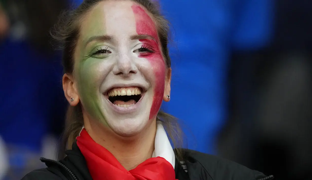 Fans wanita Italia tersenyum sebelum dimulainya pertandingan semifinal EURO 2020 antara Italia dan Spanyol di Stadion Wembley di London (7/7/2021). (AP Photo/Frank Augstein, Pool)