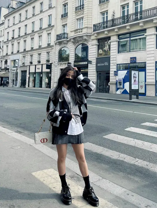 Dengan tema street style, Jisoo tampil cantik mengenakan white shirt dengan vest dan cardigan sebagai luarannya. Bawahannya Jisoo mengenakan mini skirt. (instagram/sooyaaa_)
