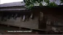 Rumah model lama dengan bangunan sederhana dan banyak dinding yang  menggunakan anyaman bambu. Tampak di bagian samping digunakan untuk mengantungkan beberapa pakaian. [Youtube/Melly Lee]
