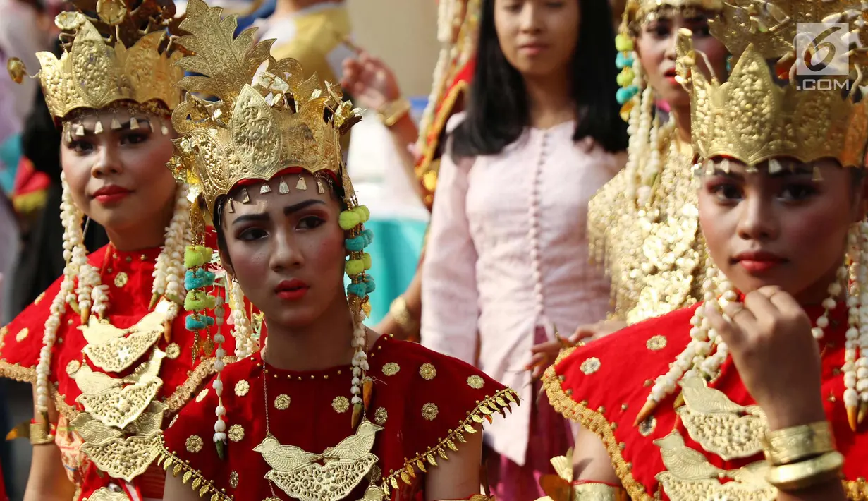 Sejumlah wanita mengenakan pakaian adat saat melakukan karnaval di jalan Pintu 1 Senayan, Jakarta, Minggu (24/9). Karnaval tersebut dilakukan dalam rangka HUT Gelora Bungkarno yang ke-55. (Liputan6.com/Angga Yuniar)