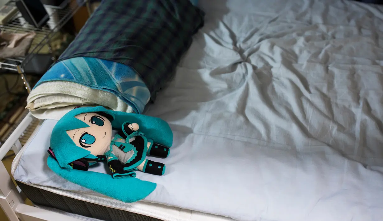 Boneka aktris virtual, Hatsune Miku yang mengenakan cincin kawin tergelat di atas tempat tidur milik seorang pria Jepang, Akihiko Kondo di Tokyo, 10 November 2018. Kondo memutuskan menikah dengan boneka anime pada 4 November lalu. (Behrouz MEHRI/AFP)