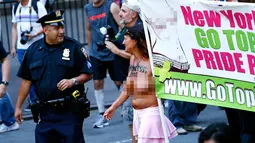 Petugas polisi berbincang dengan pengunjuk rasa saat  GoTopless Parade di New York, Amerika Serikat (28/8). Parade GoTopless Day telah ada di New York sejak 1992 silam. (AFP PHOTO / KENA Betancur)
