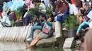 Seorang warga berselfie saat menyaksikan pertandingan antara Menteri KKP Susi Pudjiastuti dan Wagub DKI Jakarta Sandiaga Uno mengarungi danau sunter selama Festival Danau Sunter di Jakarta, Minggu (25/2). (Liputan6.com/Angga Yuniar)