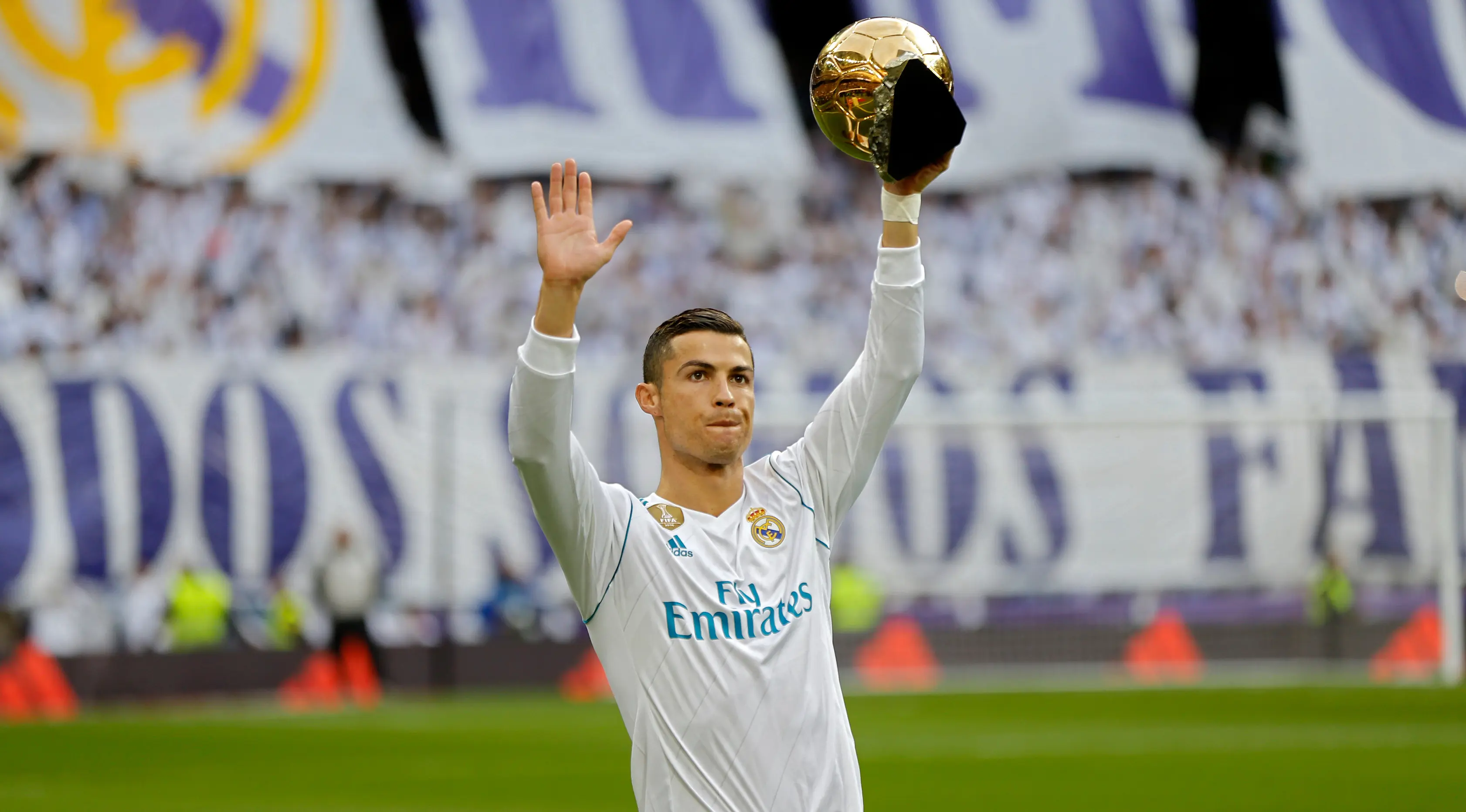 Pemain Real Madrid, Cristiano Ronaldo memamerkan salah satu trofi bola emas Ballon d'Or sebelum laga Real Madrid vs Sevilla di Stadion Santiago Bernabeu, Sabtu (9/12). Ronaldo baru saja meraih trofi kelima penghargaan Ballon d'Or 2017. (AP/Francisco Seco)