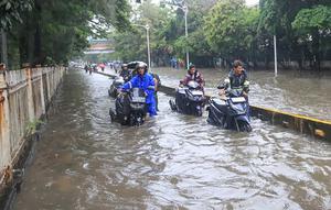 Genangan air tampak merendam beberapa ruas jalan utama, salah satunya Jalan Jembatan Tiga Raya di Jakarta Utara. Tampak dalam foto, pengendara terpaksa mendorong motornya yang mogok saat melintasi banjir yang menggenangi Jalan Jembatan Tiga Raya, Jakarta Utara, Senin (12/1/2026). (merdeka.com/Arie Basuki)