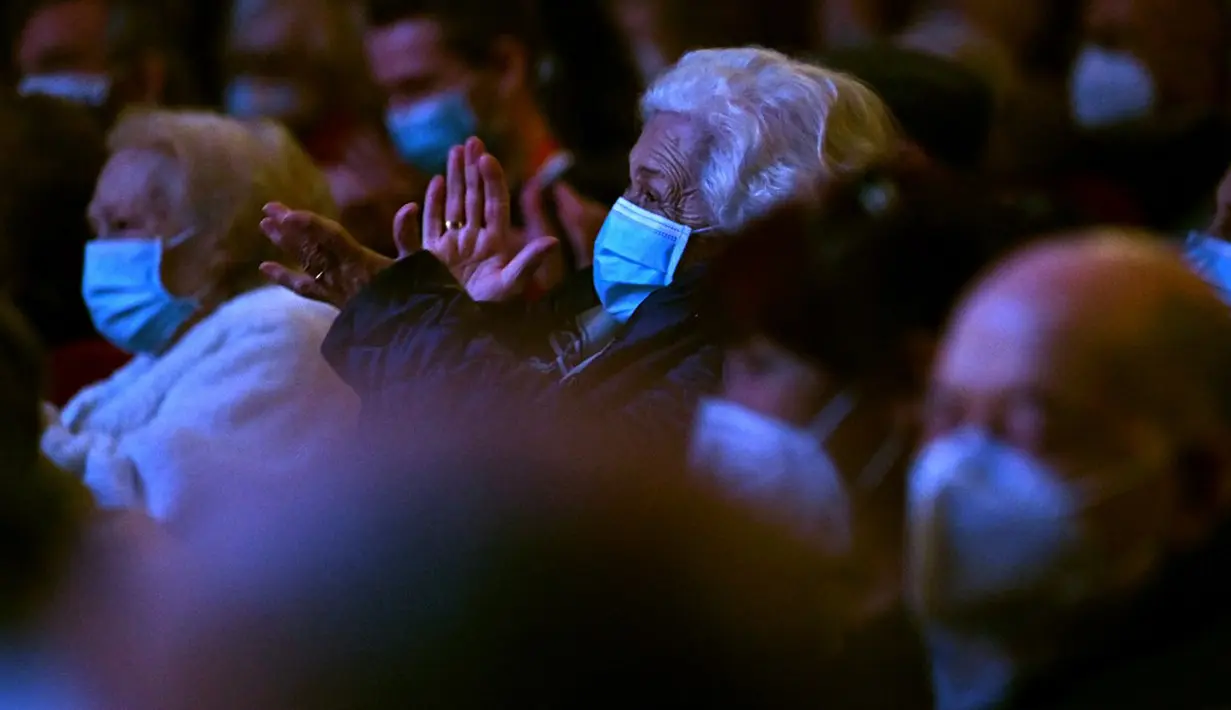 Lansia penghuni panti jompo yang telah menerima vaksin COVID-19 bertepuk tangan saat menyaksikan pertunjukan di EDP Gran Via Theatre, Madrid, Spanyol, 24 Februari 2021. Pandemi COVID-19 di Spanyol mencatatkan kematian sekitar 68.000 orang dari lebih dari 3,1 juta kasus. (GABRIEL BOUYS/AFP)