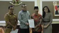 Menpan RB Syafruddin (kedua kiri) dan Bupati Kabupaten Solok Selatan Muzni Zakaria (kedua kanan) menunjukkan berkas CPNS dokter gigi Romi Syofpa Ismael di kantor Kemenpan RB, Jakarta, Senin (5/8/2019). (Liputan6.com/Angga Yuniar)