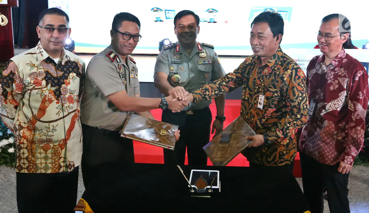 Direktur kelembagaan PT BRI, Sis Apik Wijayanto (kedua kanan) berjabat tangan dengan Kepala Pelayanan Markas Besar Polri Kombes Budi Wijanarko saat acara peluncuran Kartu BRI Promoter, Jakarta, Jumat (16/5). (Liputan6.com/Johan Tallo)