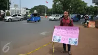Aksi Susanto asal Pandeglang, Banten, di depan Istana Merdeka, Jakarta, Jumat (20/11). Bapak ini meminta Presiden Jokowi membeli ginjalnya guna membiayai operasi transplantasi hati anaknya yang disinyalir mencapai Rp.1,2M. (Liputan6.com/Gempur M Surya)