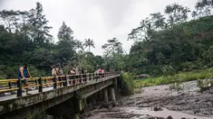 Sejumlah turis melihat aliran lahar dingin Gunung Agung di Karangasem, Bali (29/11). Ribuan turis diperkirakan akan meninggalkan Bali pada 30 November menyusul penutupan bandara akibat Gunung Agung Meletus. (AFP Photo/Juni Kriswanto)