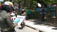Personel Pol PP Kota Palu menindak warga yang kedapatan tidak menggunakan masker di tempat publik. (Foto: Heri Susanto/ Liputan6.com).