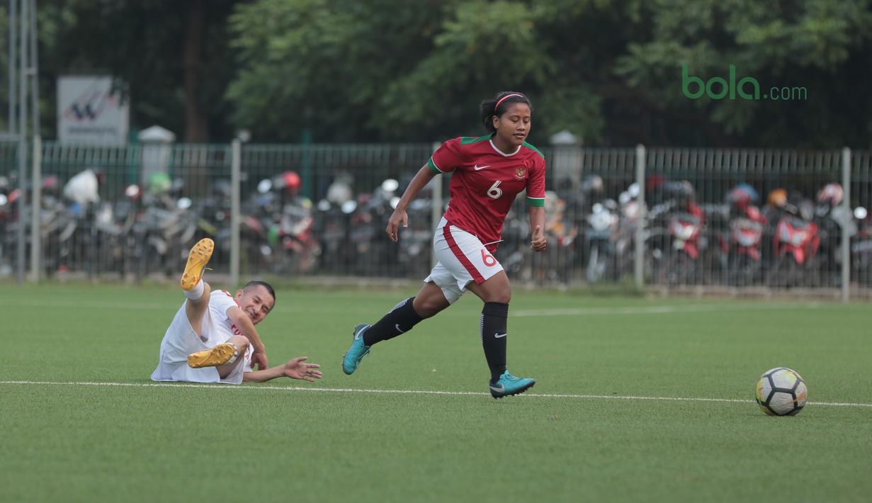 Pemain Timnas Wanita Indonesia, Nurlaili (kanan) berhasil melewati pemain Legenda Indonesia pada laga uji coba di Lapangan ABC Senayan, Jakarta, Kamis (5/4/2018). Timnas Wanita Indonesia menang 3-2. (Bola.com/Nick Hanoatubun)